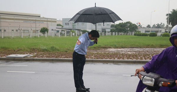 Ông chủ người Nhật ở Việt Nam đứng dưới mưa mời khách vào đổ xăng. 
